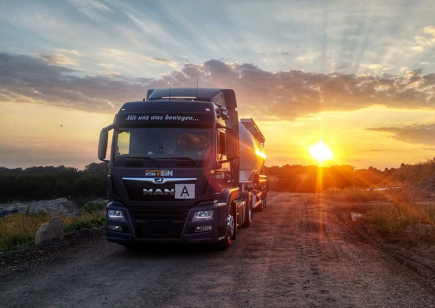 Dunkler Containertransporter beim Sonnenuntergang
